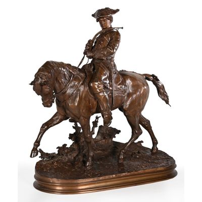 a bronze statue of a man riding a horse on a wooden base