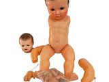 a baby doll sitting on top of a plastic bag