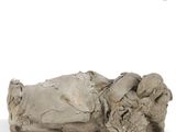 an old statue of a woman laying down on a white surface