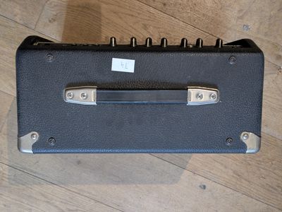 un étui de guitare noir posé sur un plancher en bois