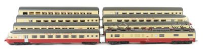two model trains sitting side by side on a white surface