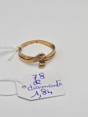 une bague en or sertie d'un diamant, à côté d'une étiquette de prix
