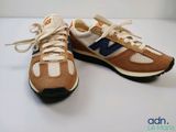 pair of new balance shoes on white surface with orange and blue accents