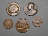 several coins are shown on a gray surface with a picture of a man in a suit