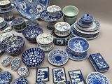 de nombreuses assiettes et bols bleus et blancs sur la table