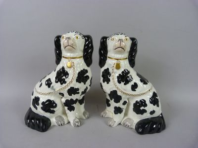 paire de figurines de chiens noir et blanc avec une chaîne autour du cou