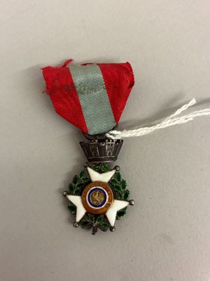 la médaille est accrochée à un ruban rouge orné d'une étoile blanche