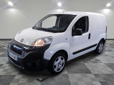 la petite camionnette blanche est garée sur un carrelage à carreaux