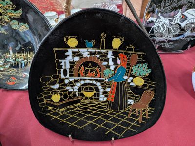 une assiette noire avec une image dessus, posée sur une table