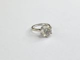 a close up of a diamond ring on a white surface