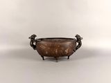 an antique bronze bowl with two handles and two birds on each side