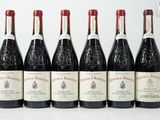 six bouteilles de vin sont alignées sur une surface blanche