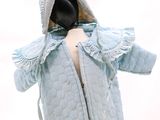 un mannequin vêtu d'un manteau bleu à capuche