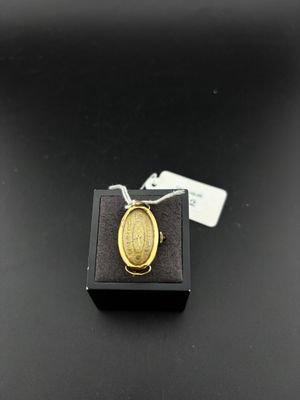a gold ring with a oval design on a black surface