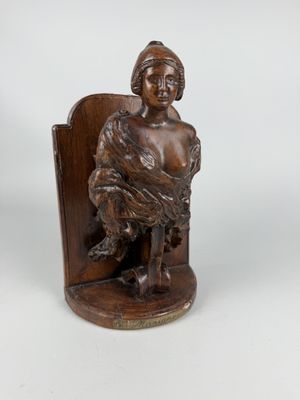 an image of a wooden statue of a woman sitting on a chair