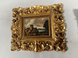 a picture of a painting hanging on a wall next to a candle