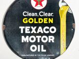 une affiche indiquant « Huile moteur Texaco : propre, limpide, dorée »