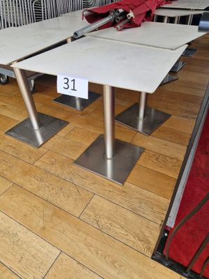 three tables with a red umbrella on them in a store