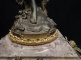 a statue of a woman holding a bird on top of a table