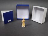 a small figurine that is standing in front of a box