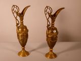 deux vases en or posés l'un à côté de l'autre sur une table