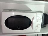 a microwave that is sitting on a shelf in a kitchen