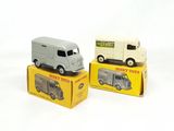 deux camions miniatures posés sur des cartons, sur une surface blanche