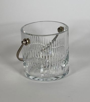 un seau à glace en verre muni d'une poignée, posé sur une table