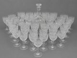 many wine glasses and a bottle sitting on a table