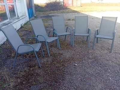 five lawn chairs sitting in a circle in front of a building