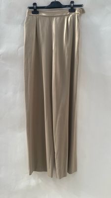 a beige skirt hanging on a hanger on a white wall
