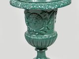 a green vase that is sitting on a pedestal