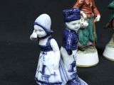 three figurines of people are standing on a black surface