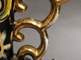 a close up of a vase with a gold handle