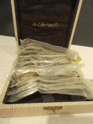 six cuillères dans une boîte posée sur une table