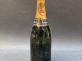 a bottle of champagne on a table with a gray background