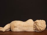 an image of a statue of a child laying on a table