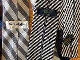 three ties are lined up on a wooden table with a tag
