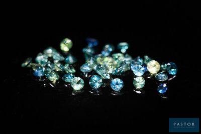 une multitude de losanges bleus et verts sur un fond noir