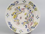 une assiette blanche décorée de fleurs bleues et jaunes