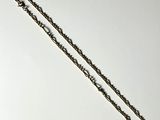a silver chain with a heart on it on a white surface