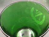 a green glass bowl with a green crest on it