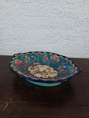 a blue bowl sitting on a wooden table with a white wall in the background