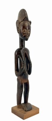 wooden statue of a man holding a bag on a wooden base