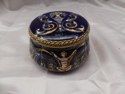 une boîte bleue et dorée posée sur un tissu blanc