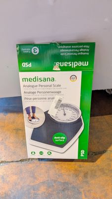 La boîte de la balance électronique est posée par terre.