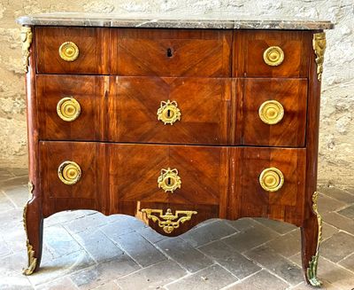 a dresser with a marble top on a brick floor