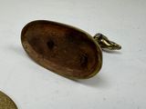 a small coin sitting next to a small bronze object