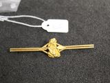 a close up of a gold hair pin with a tag on it
