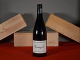 a bottle of wine sitting on a table next to two wooden boxes